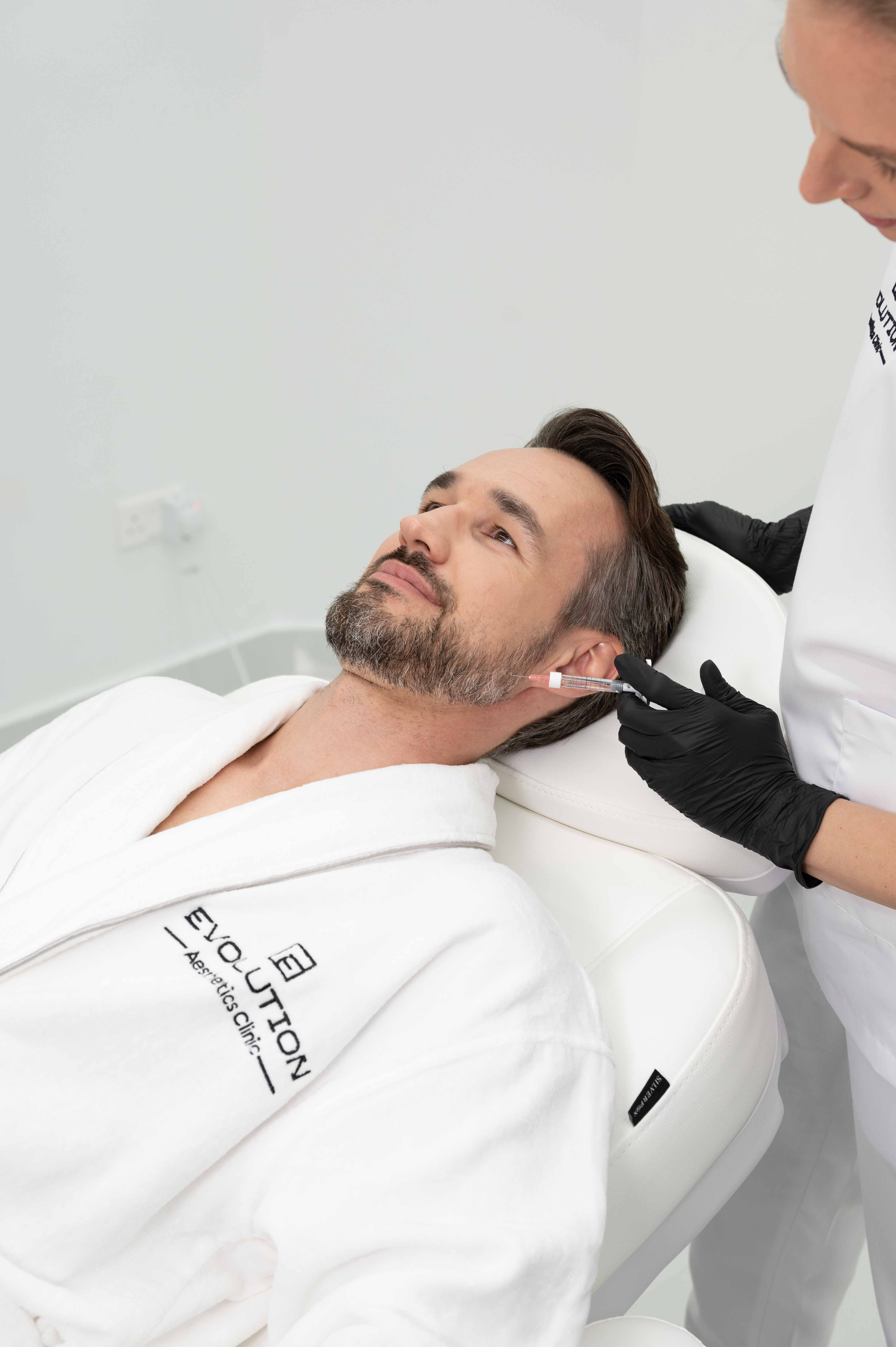 Clinician performing an injectable treatment along a patient’s jawline