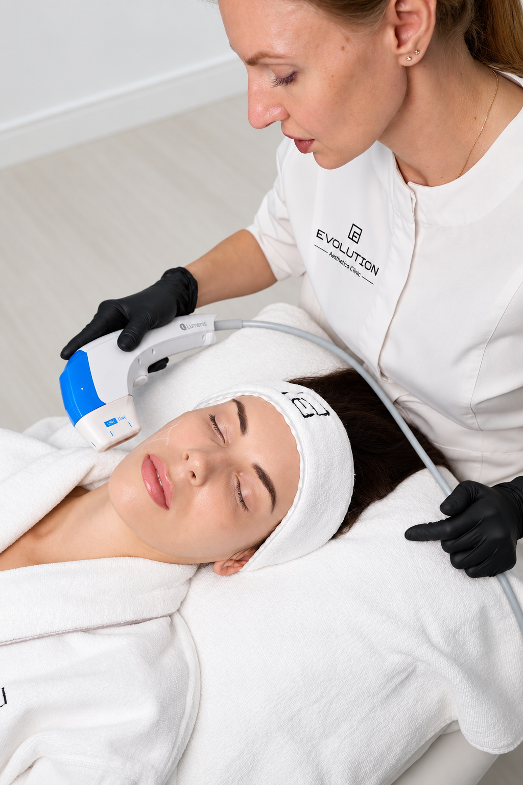 Practitioner using a blue Ultraformer MPT handpiece during facial treatment