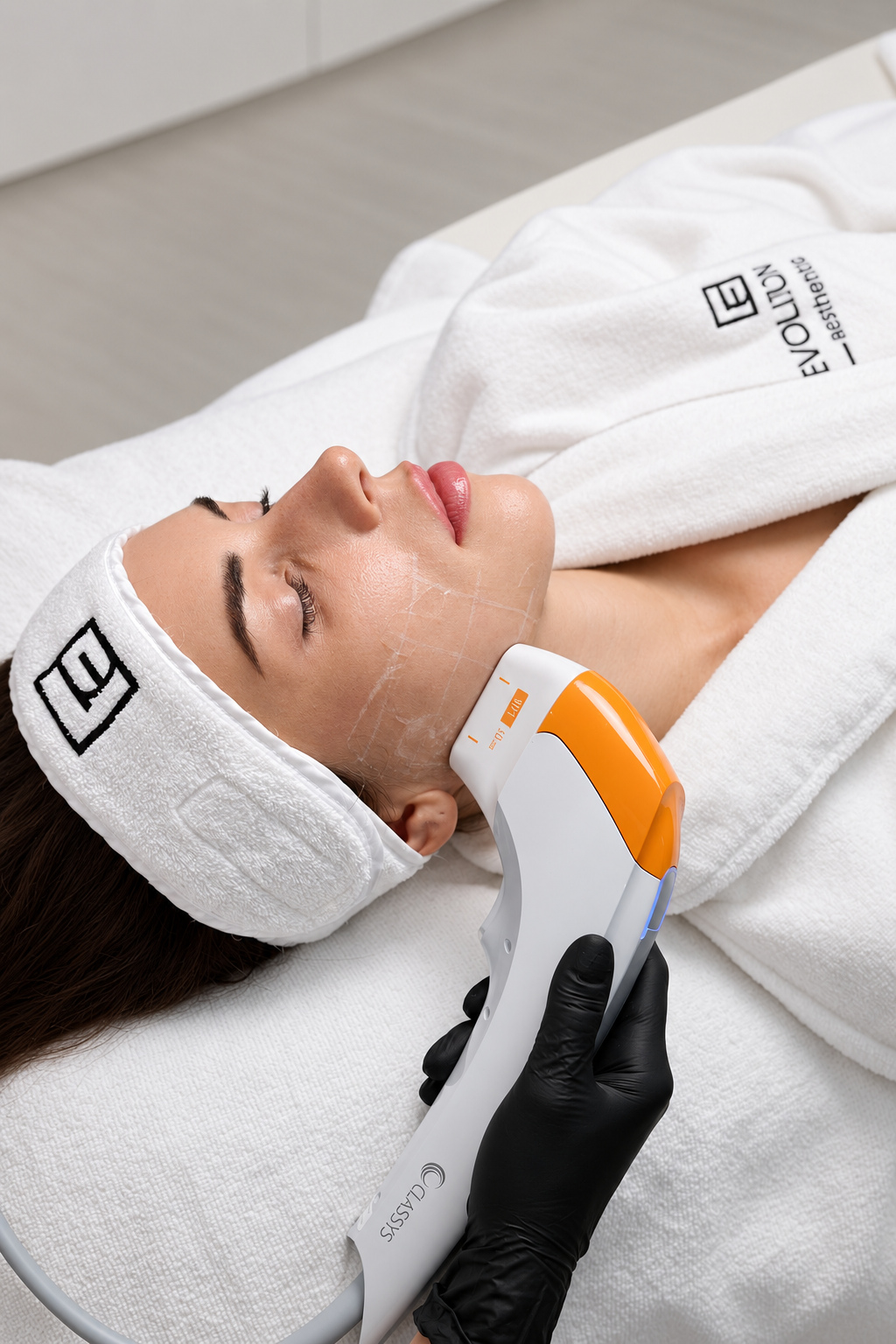 Orange Ultraformer MPT handpiece applied along a patient jawline