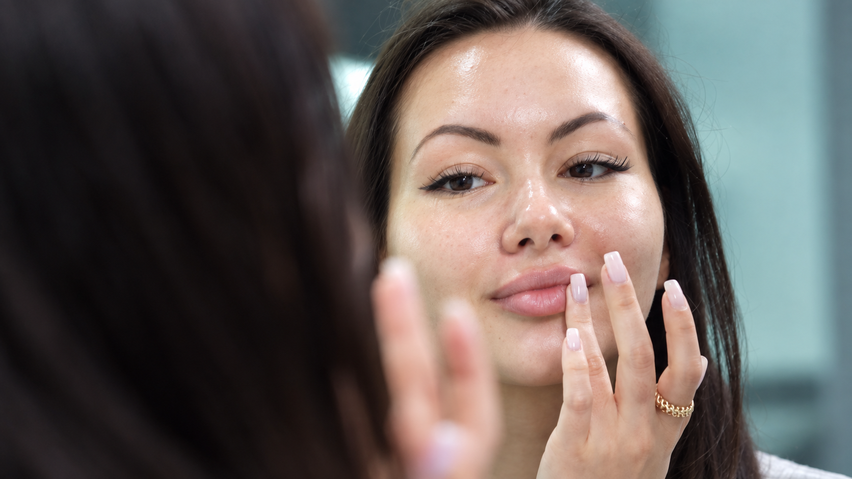 Woman looking at her lips in a mirror