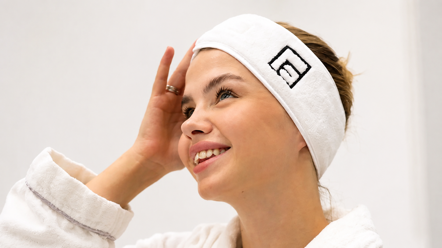 AI-enhanced photograph of a smiling patient wearing a clinic headband and white robe