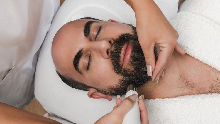 Clinician examining the beard area of a reclining patient