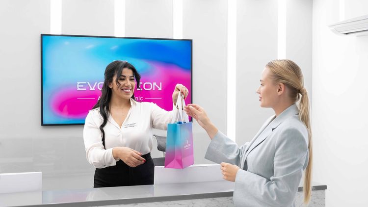 Clinic staff handing a branded bag to a visitor