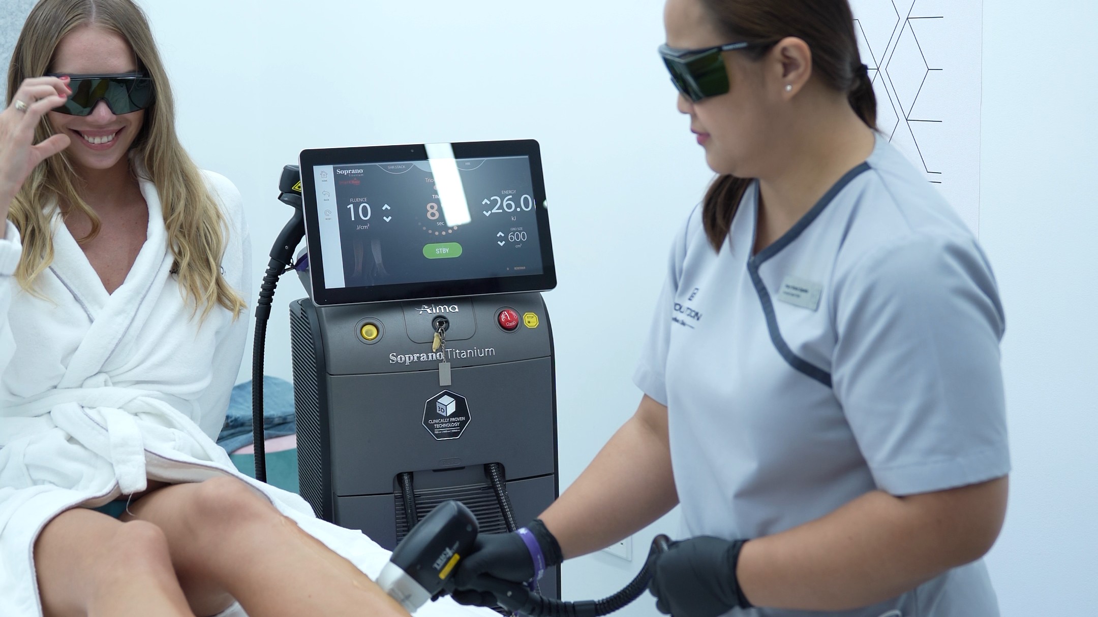 Shows patient, clinician and the exact Soprano Titanium device together; bright, positive